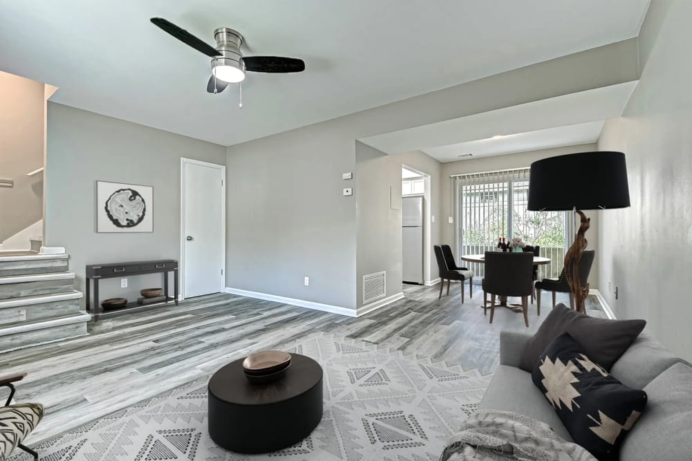 Spacious living room with a comfortable couch, ceiling fan and a dining area with a table and chairs at Woodside Village in Valparaiso, Indiana