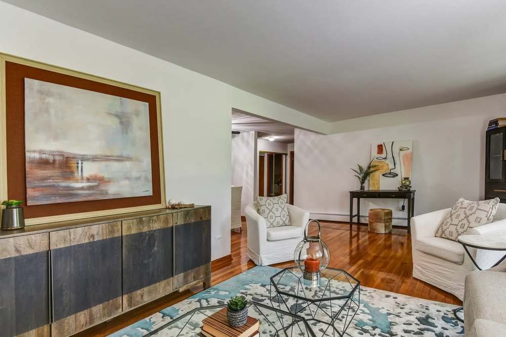Bright living room with chairs and a big mirror at Park Ridge Commons in Des Plaines, Illinois