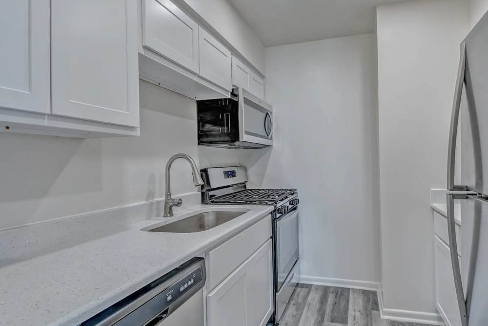 Kitchen with a microwave, white wooden cabinets and refrigerator at Woodside Village in Valparaiso, Indiana