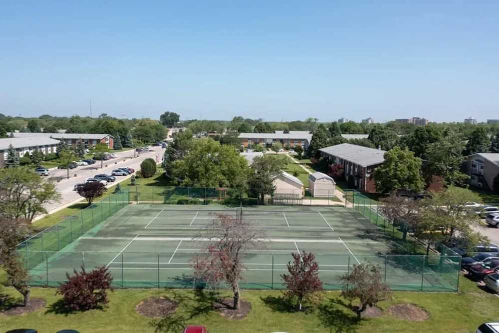 Tennis court surrounded by greenery at Park Ridge Commons in Des Plaines, Illinois