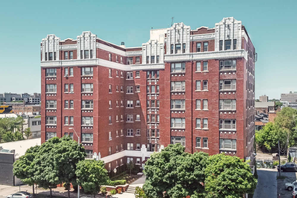 View of exterior of apartments and green lawn at Detroit Living in Detroit, Michigan