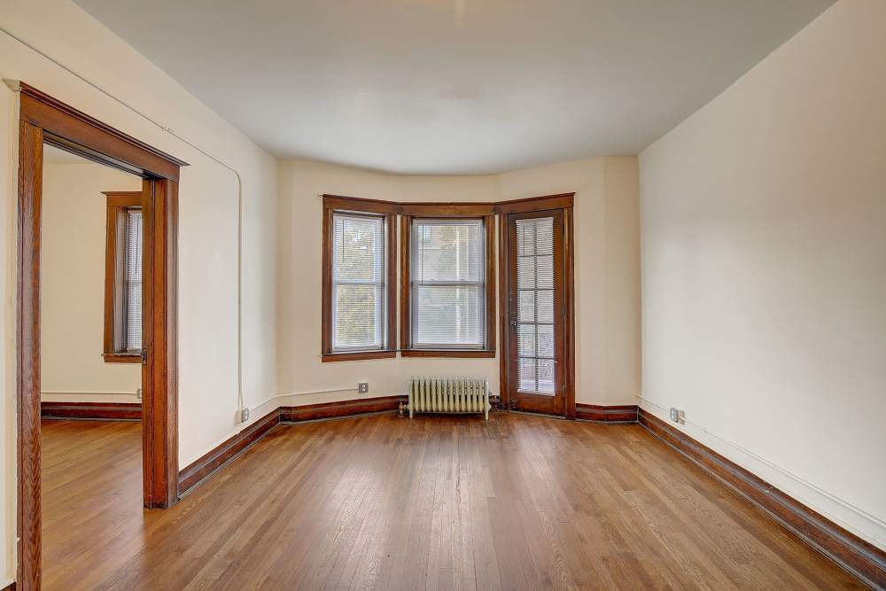 Open layout living room with hard-wood style flooring at Detroit Living in Detroit, Michigan