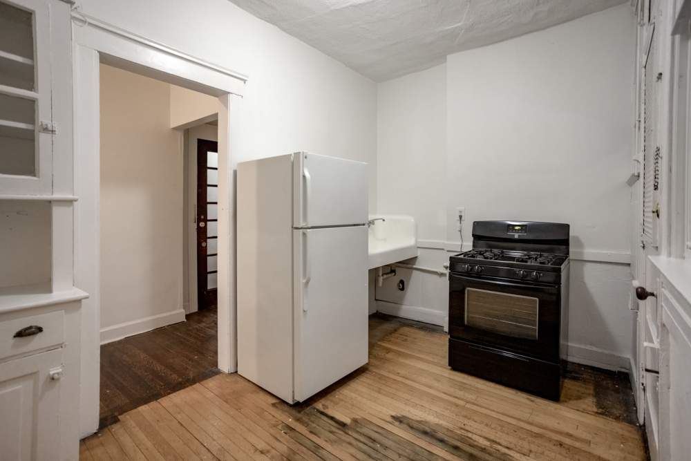 Kitchen with refrigerator, stove and cabinetry at Detroit Living in Detroit, Michigan