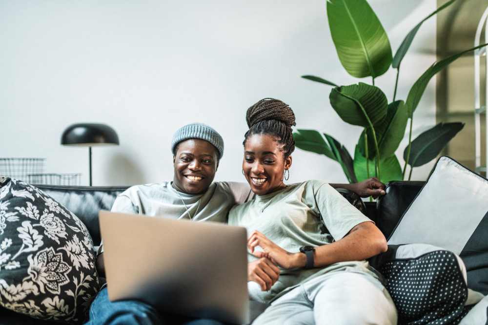 Couple browsing the web on their laptop in spacious apartment home at Elms Shady Grove in Rockville, Maryland