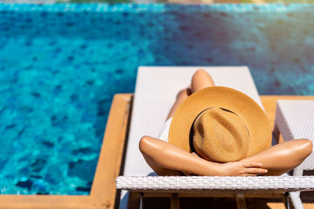 Woman relaxing by the swimming pool at Sherwood Pointe Apartments in Shawnee, Oklahoma