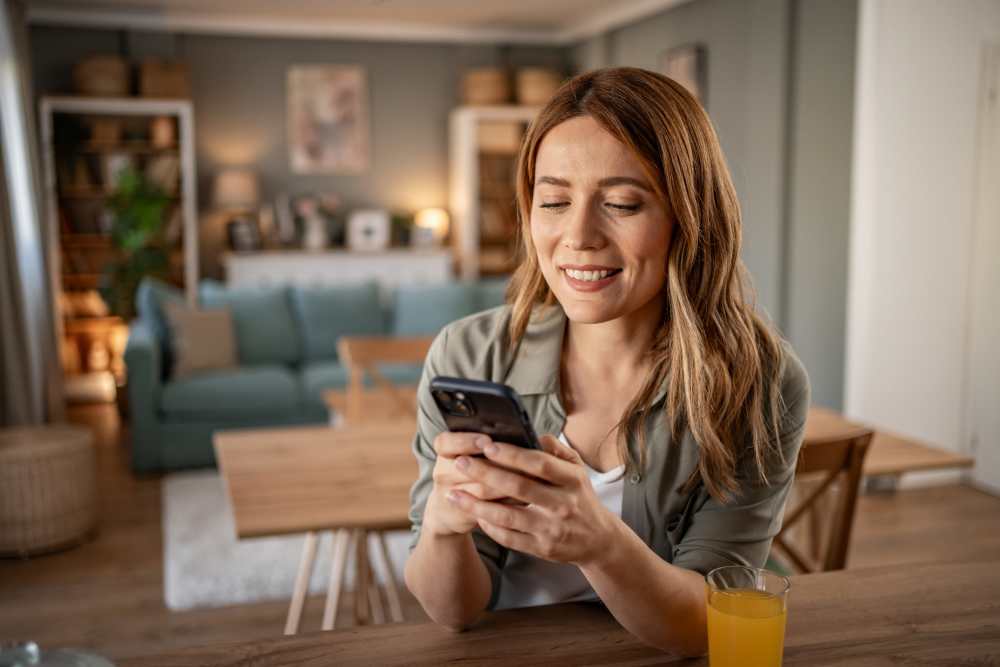 Resident on her phone in her new apartment at Detroit Living in Detroit, Michigan