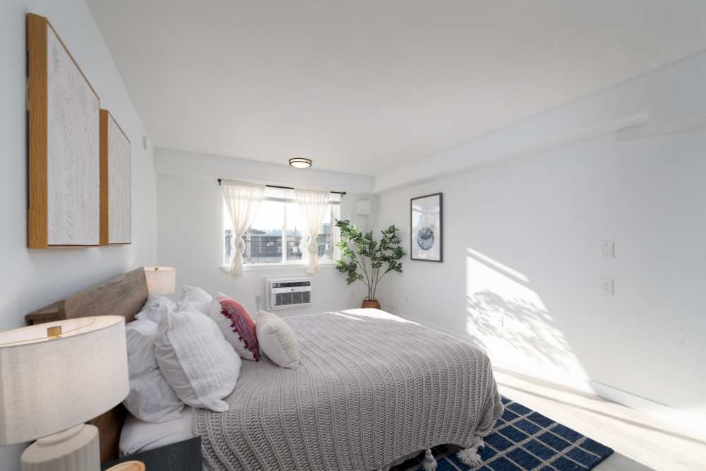 Large comfortable bed with plush carpeting at Pinnacle Point Apartments in Fife, Washington  