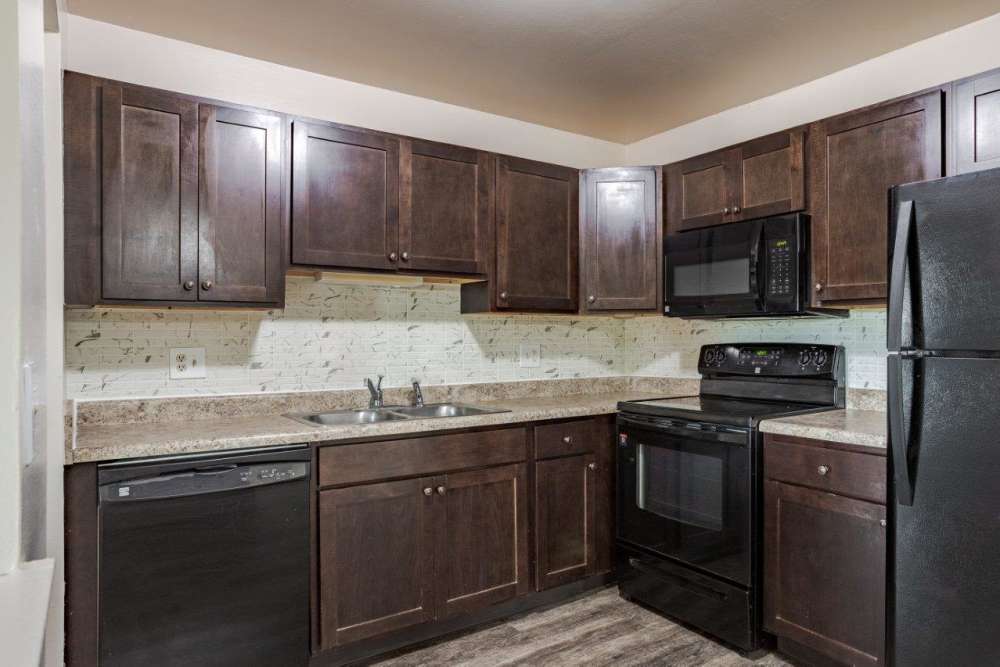 Kitchen with modern black appliances at Pavilion Court Apartment Homes in Novi, Michigan