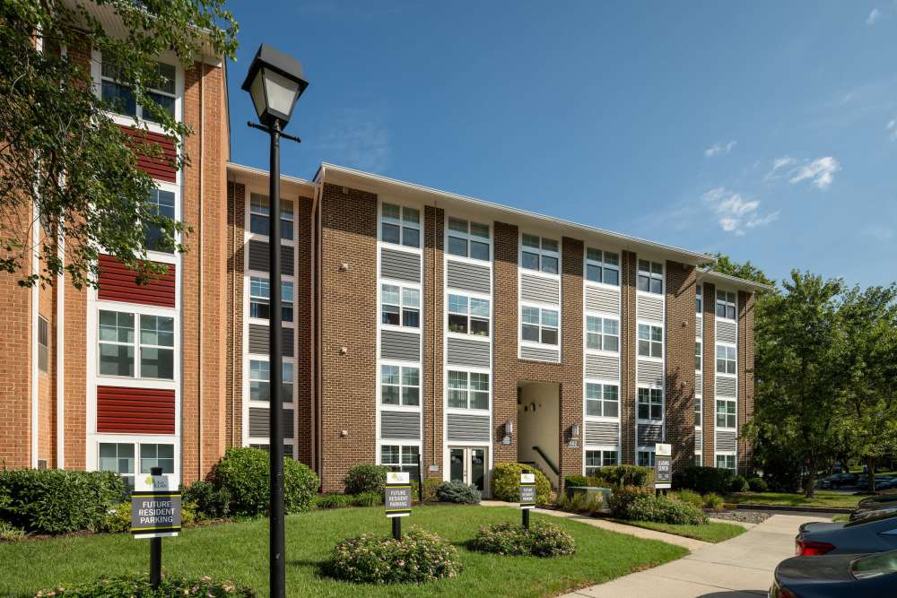 Community building exterior view with sidewalk at The Elms at Old Mill in Millersville, Maryland