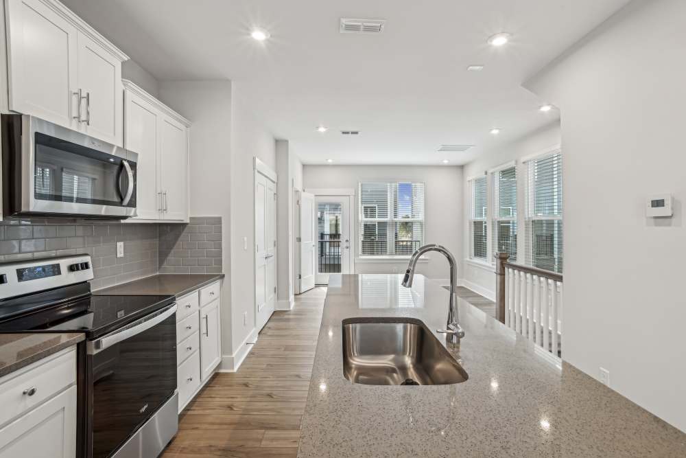 Charming kitchen with polished interiors, wood-style flooring and latest appliances at Reve Noda Junction in Charlotte,North Carolina