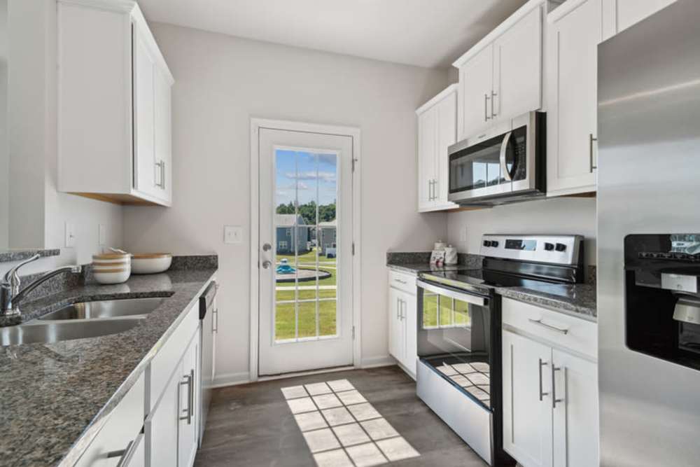 Modern kitchen with fridge at Norman Ridge Townhomes in Terrell, North Carolina