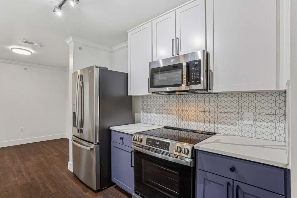 Kitchen with fridge, oven and cabinets at Cypress in McKinney, Texas