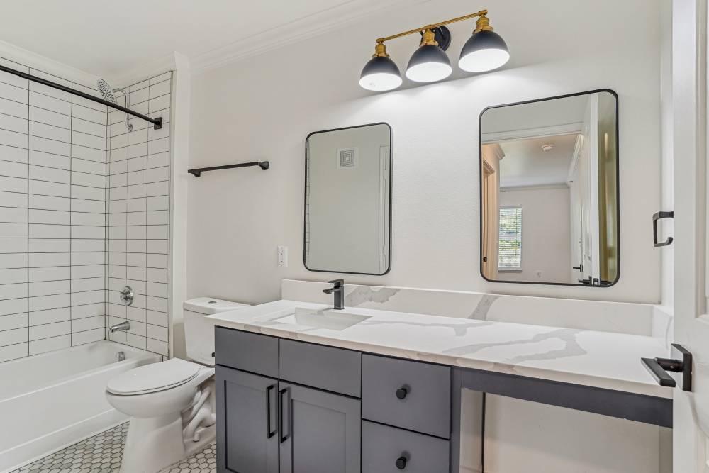 Bathroom with commode and mirror at Cypress in McKinney, Texas