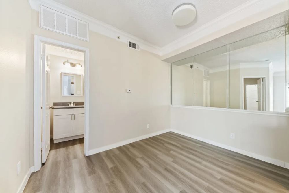 Bright bathroom connected to spacious bedroom with wood-style flooring at Benton in Dallas, Texas, 