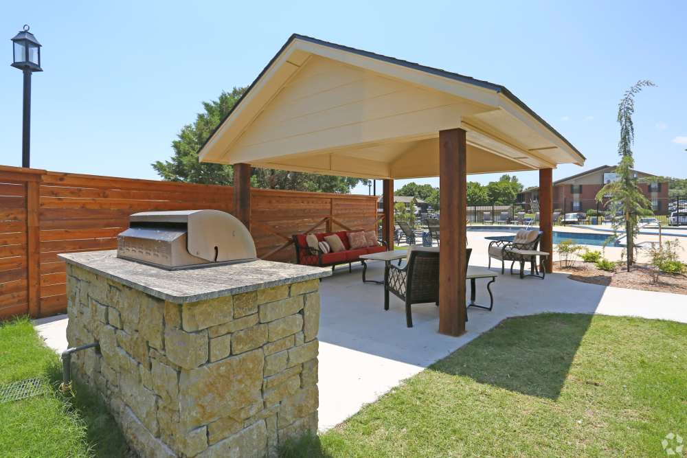 Covered BBQ area with grill stations at Oxford Oaks Apartments in Edmond, Oklahoma