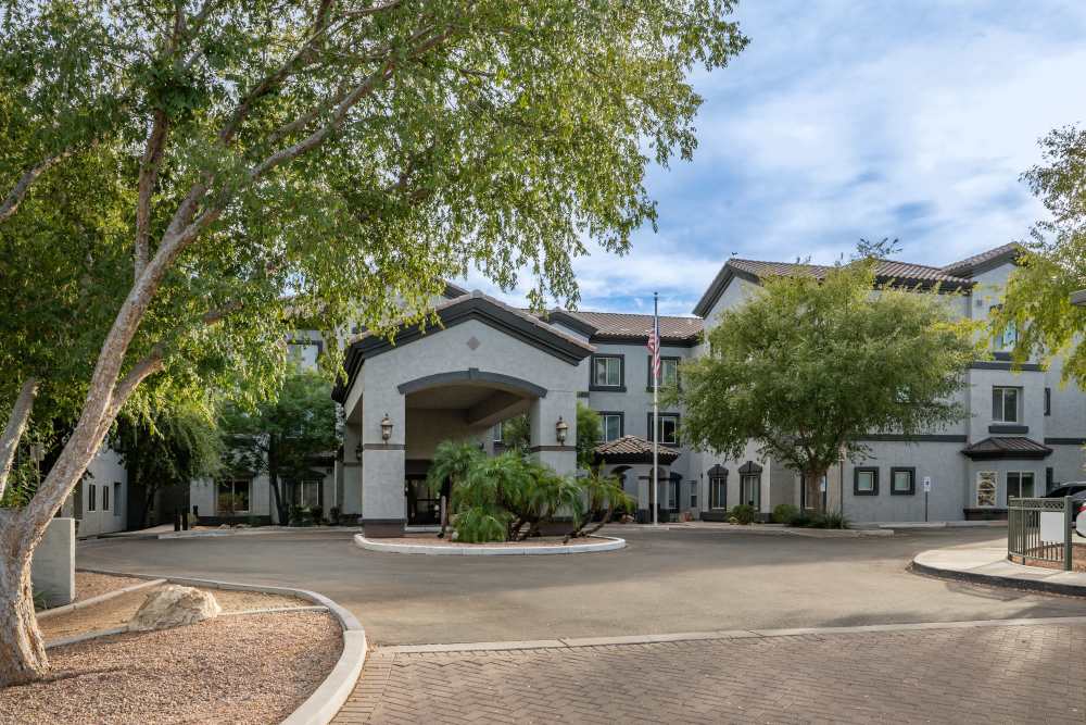 Entrance of an apartment complex with trees around it at Ridge at the Stratford in Phoenix, Arizona