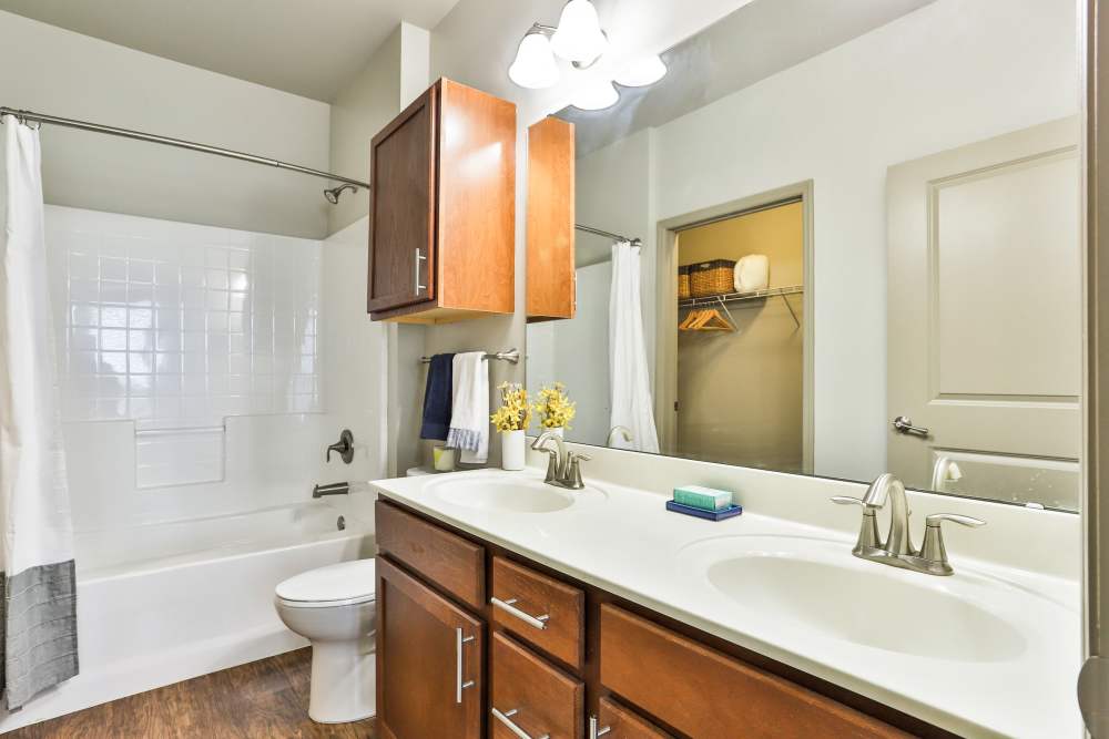 Bathroom with bath tube and vanity mirror at Residences at The Streets of St. Charles Apartment Homes in Saint Charles, Missouri