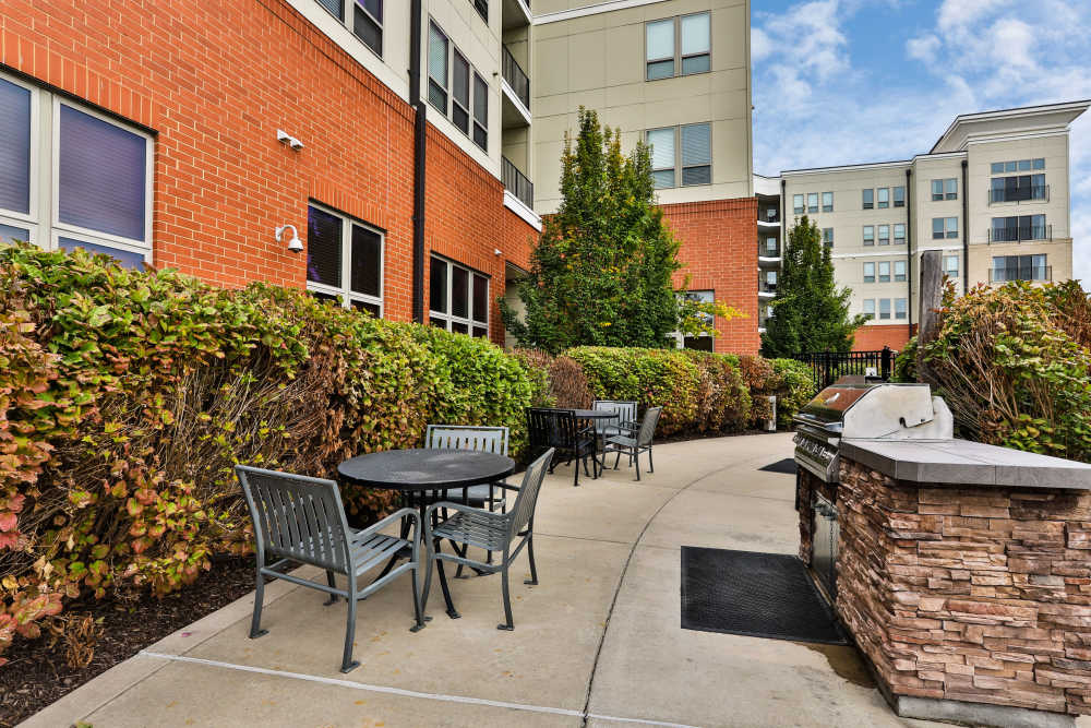 Outside seating and grilling station at Residences at The Streets of St. Charles Apartment Homes in Saint Charles, Missouri