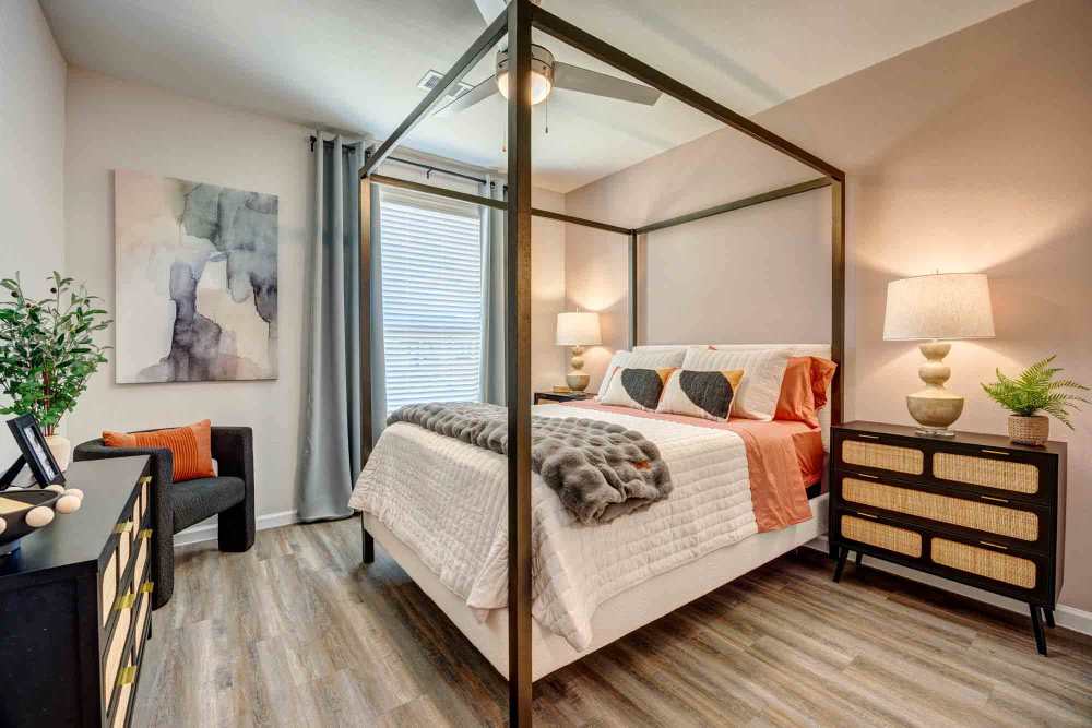 Bedroom features wood-look flooring at The Abbey at Veramendi in New Braunfels, Texas