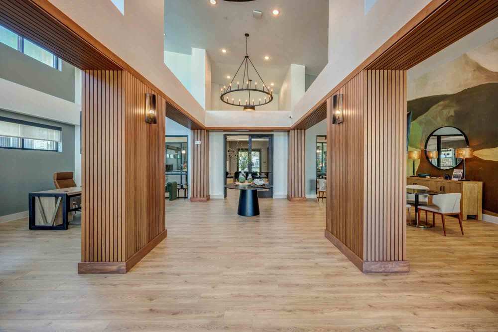  Lobby's hardwood floor is showcased; wooden dividers line the entryway, leading to a sitting area with a table and chairs at The Abbey at Veramendi in New Braunfels, Texas