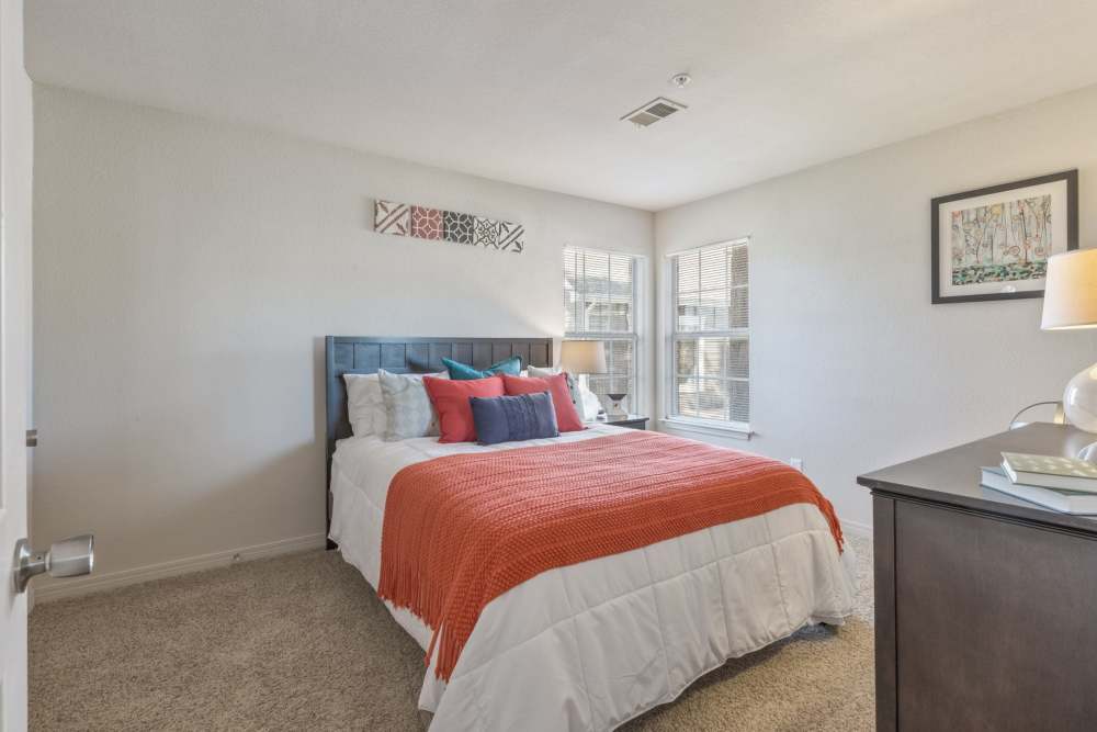 Bedroom with plush carpeting at Villas at Bailey Ranch Apartment Homes in Owasso, Oklahoma