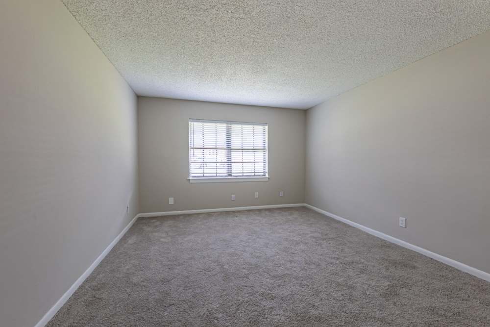 Bedroom with plush carpeting and large window at Huffman Mill Townhomes in Burlington, North Carolina,