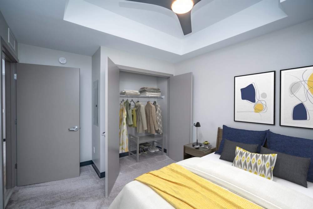 A cozy bedroom with a comfortable bed, a spacious closet, and a ceiling fan at Diamond Place I in Grand Rapids, Michigan