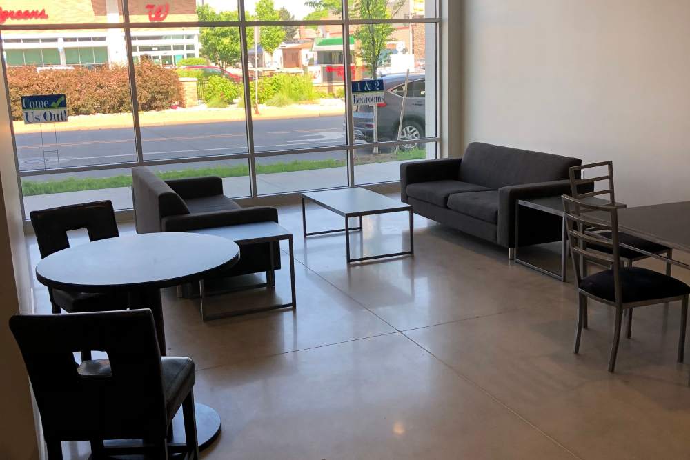 Spacious living room with chairs and panoramic windows at Leo and Alpine in Grand Rapids, Michigan