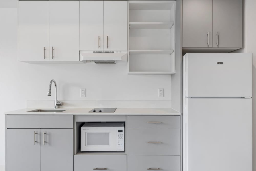 Modern kitchen with white and gray cabinets, stainless steel sink, and appliances at Koz on Killingsworth in Portland, Oregon