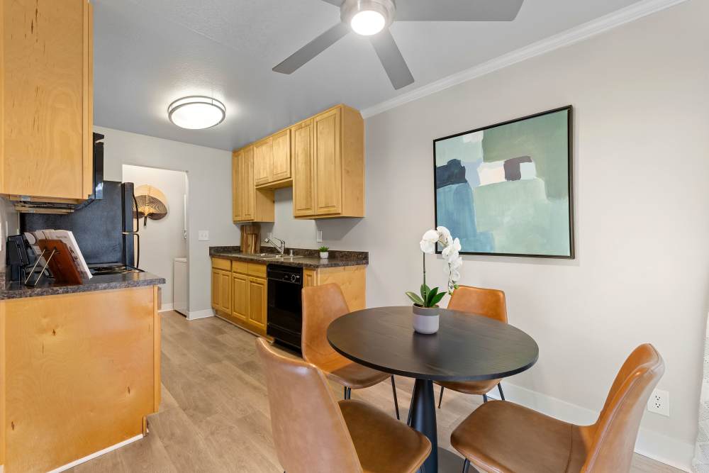 Modern dining area with a round table, stylish chairs, and artwork at Sofi Laguna Hills in Laguna Hills, California