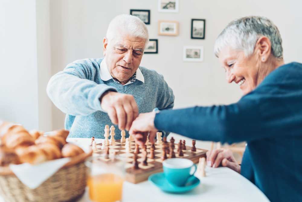 Residents of Keystone Place at Beachwalk enjoying a snack and Chess in Fort Myers, Florida