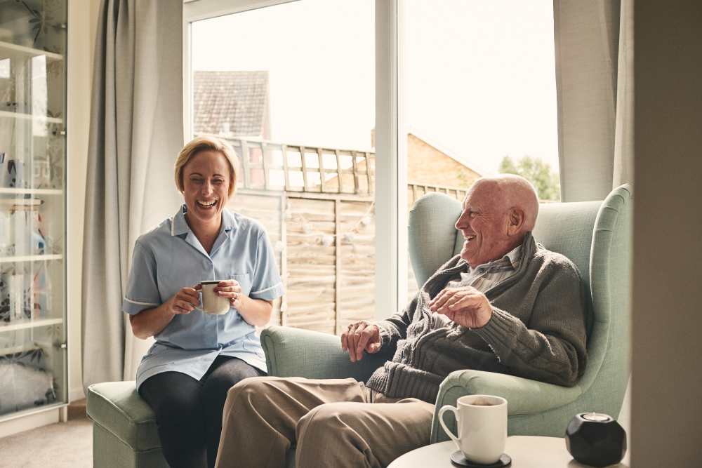 Resident talking to a caretaker over coffee at Keystone Place at Beachwalk in Fort Myers, Florida