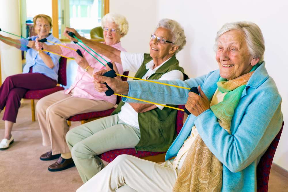 Residents enjoying elastic band exercise at Keystone Place at Beachwalk in Fort Myers, Florida