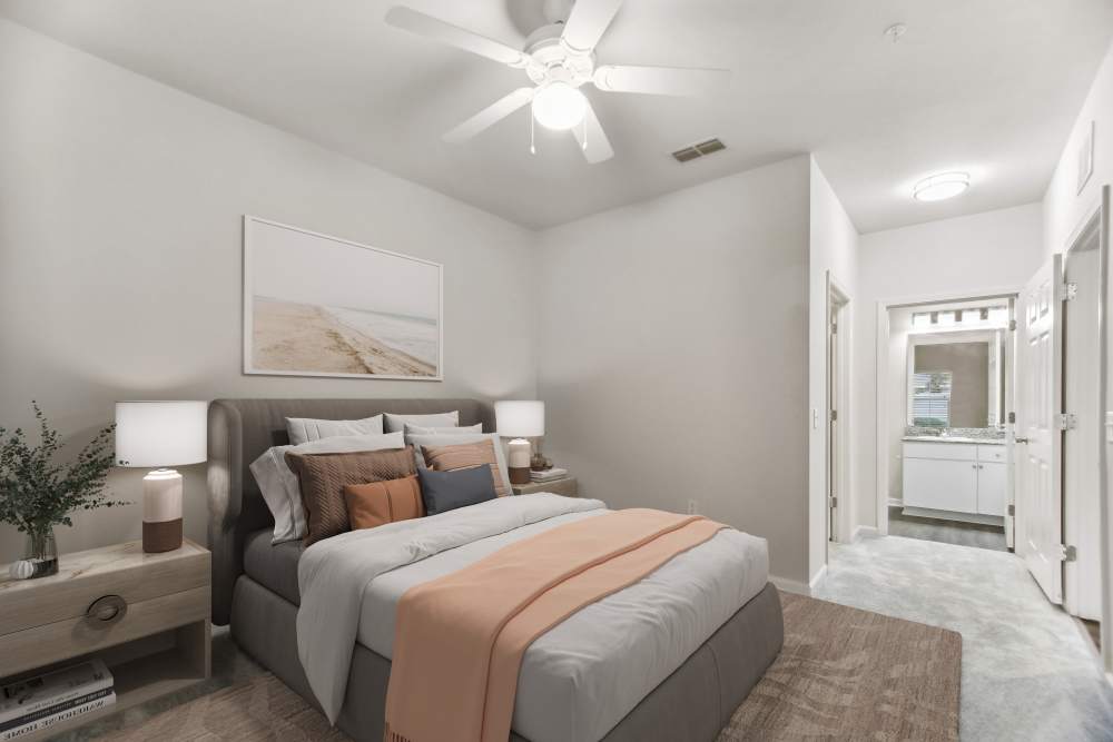 Cozy bedroom with a bed, ceiling fan and a door leading to bathroom at The Haven At West Melbourne in West Melbourne, Florida