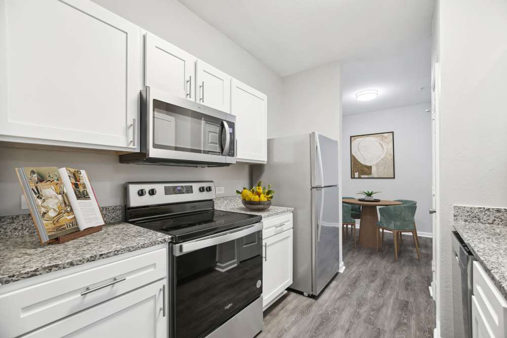 Modern kitchen with wooden cabinets and stainless-steel appliances at The Haven At West Melbourne in West Melbourne, Florida