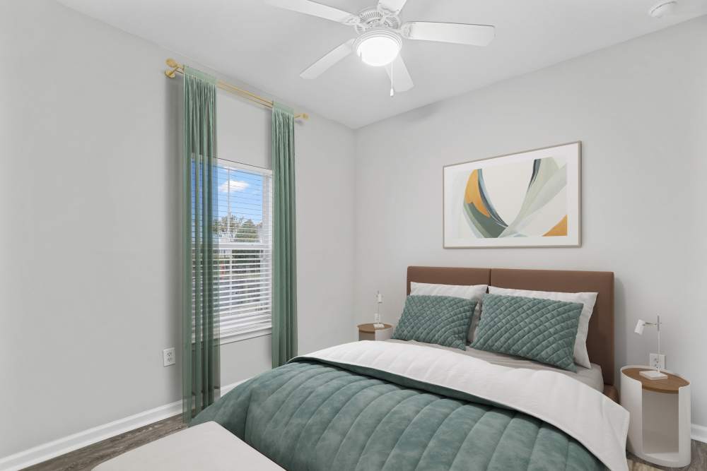 Spacious bedroom with a comfortable bed, ceiling fan and a large window at The Haven At West Melbourne in West Melbourne, Florida