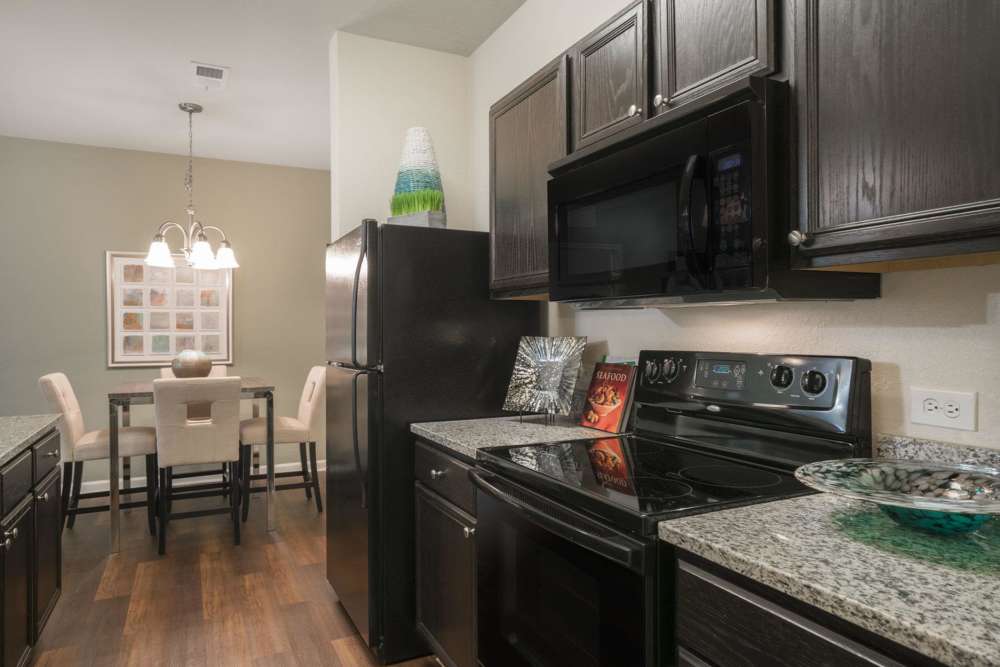 Modern kitchen with wooden cabinets, granite countertops and stainless-steel appliances at The Haven At West Melbourne in West Melbourne, Florida