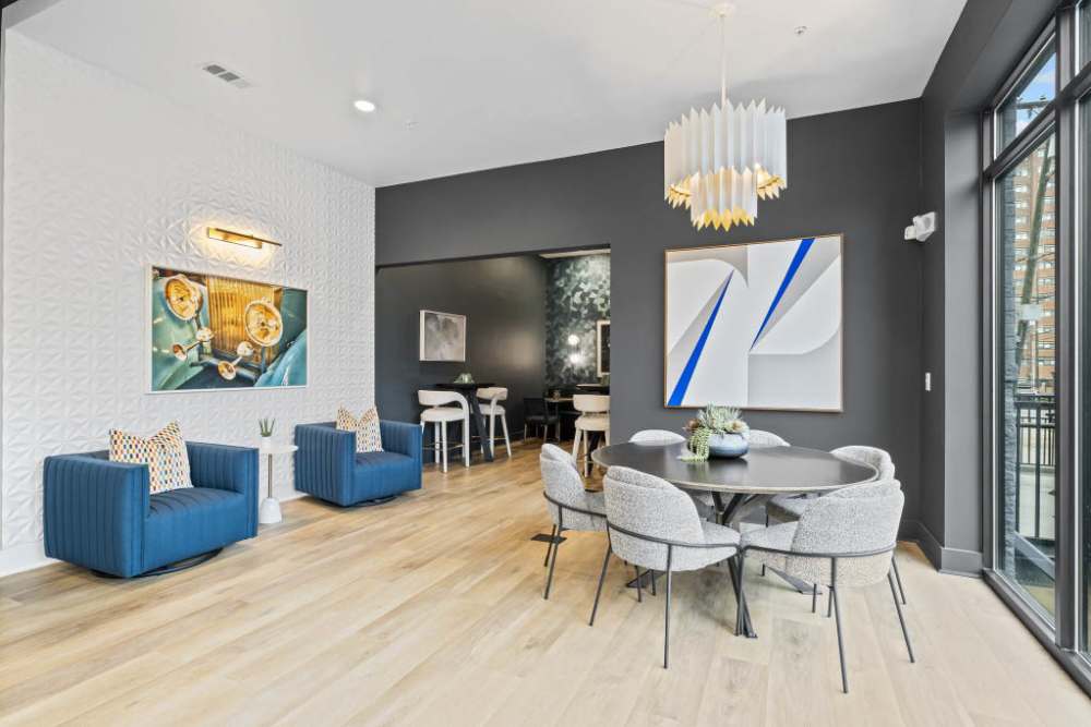 A modern living room featuring a dining table and chairs, located at Duet in Nashville, Tennessee.