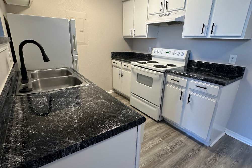 Kitchen with wooden cabinets and a refrigerator at Garrett's Landing in Lawton, Oklahoma