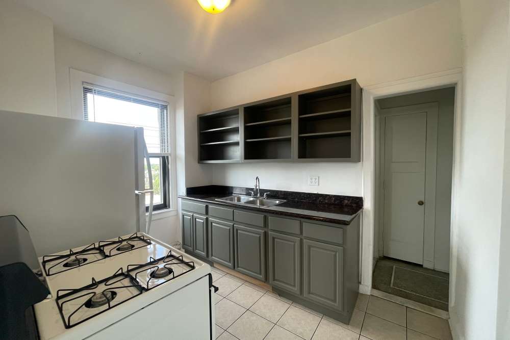 Apartment kitchen with white tile flooring and cabinetry at Detroit Living in Detroit,Michigan