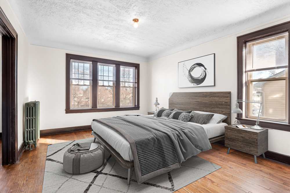 Cozy bedroom with hard-wood style flooring at Detroit Living in Detroit, Michigan