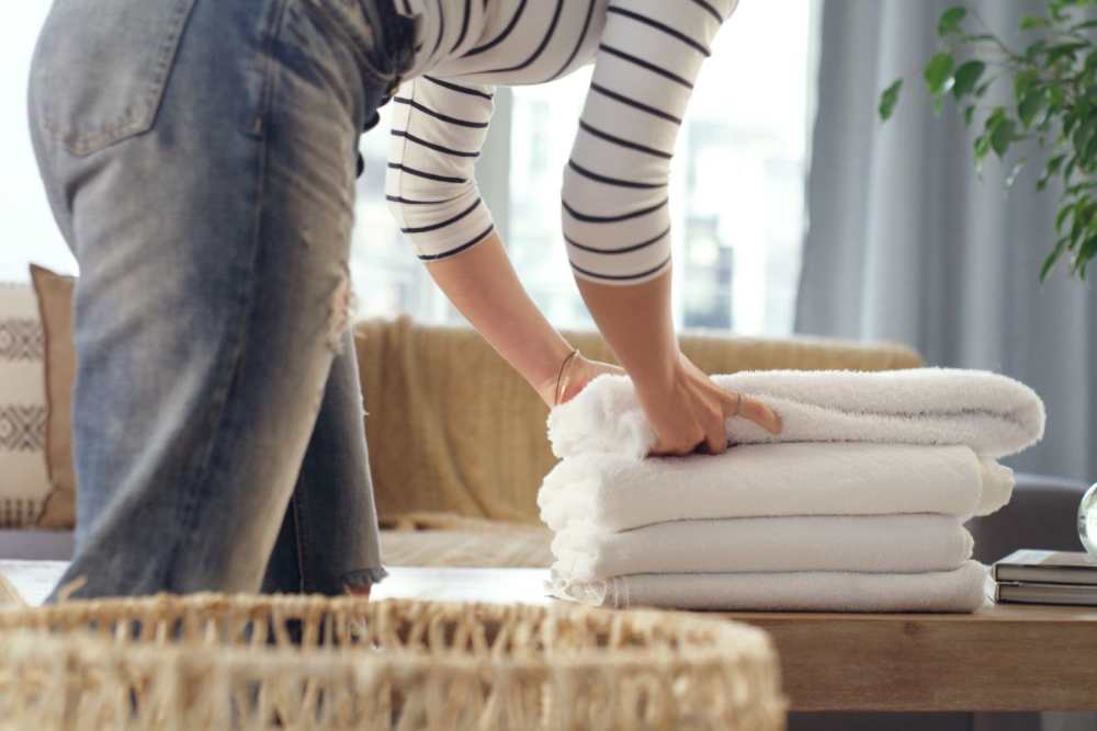 Woman folding laundry at Detroit Living in Detroit, Michigan