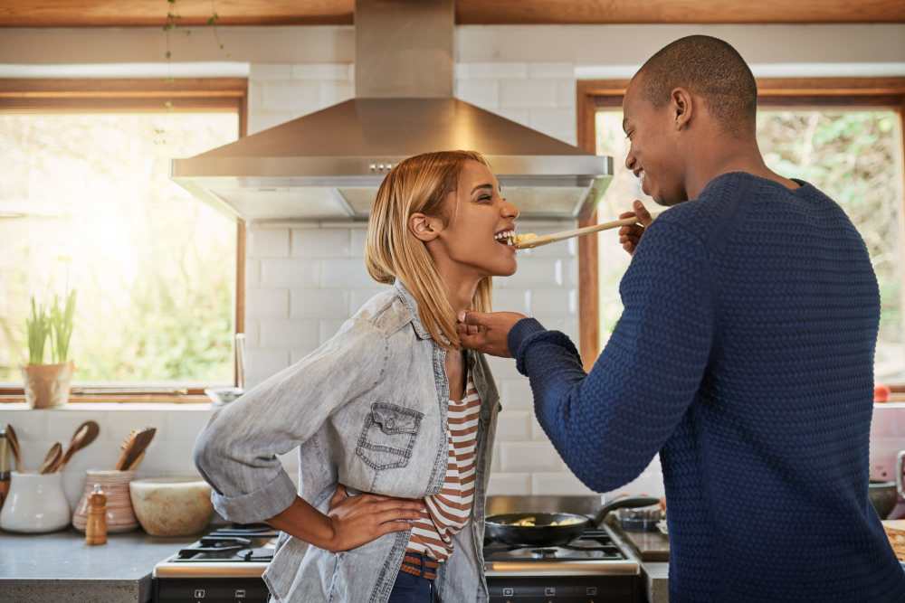 Happy couple in kitchen at Detroit Living in Detroit, 