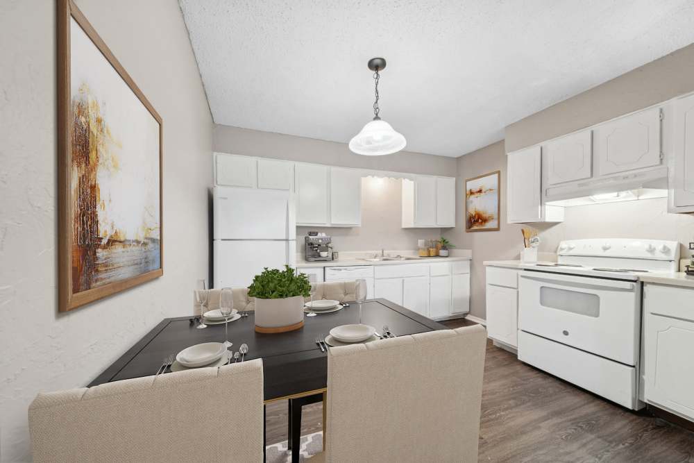 Dining area with white hardwood cabinets and chairs and tables at Cypress Point Apartments in Shawnee, Oklahoma