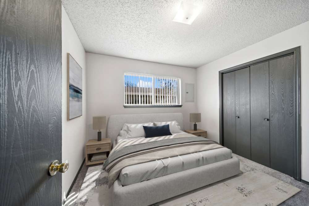 Cozy bedroom with closet and two hardwood bedside table and lamps at Sherwood Pointe Apartments in Shawnee, Oklahoma