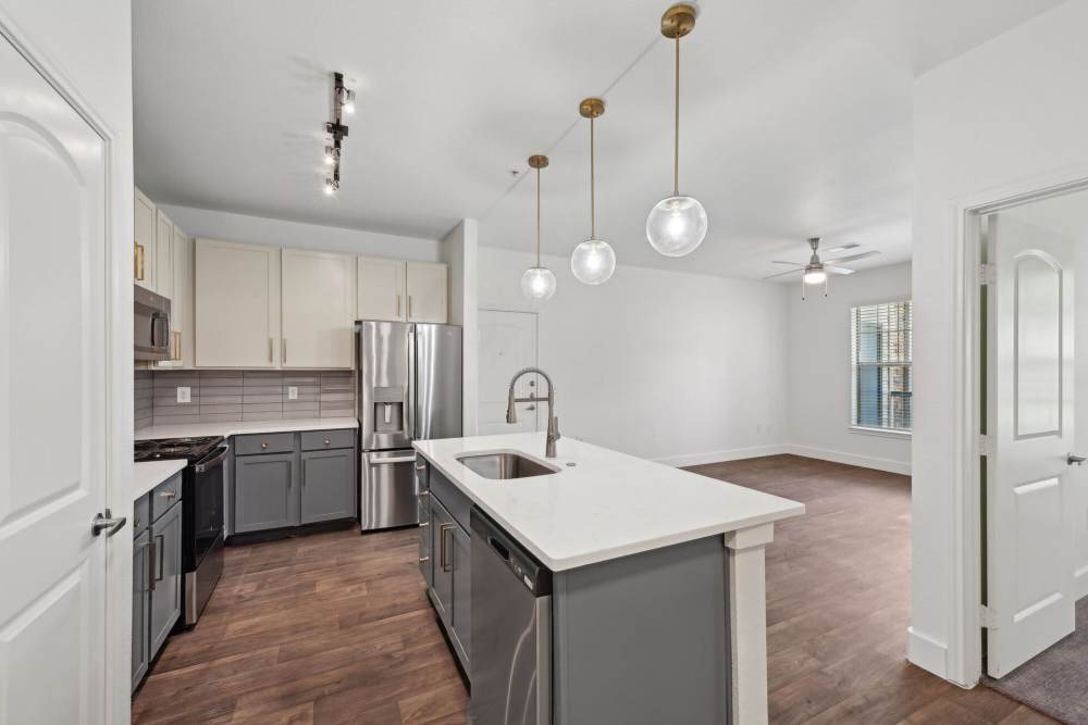 View of the kitchen with wooden cabinets and a breakfast counter at Barron Park in Pearland, Texas