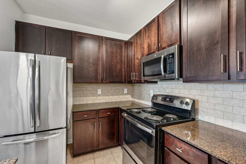 Modern kitchen with wooden cabinets and a refrigerator at Barron Park in Pearland, Texas