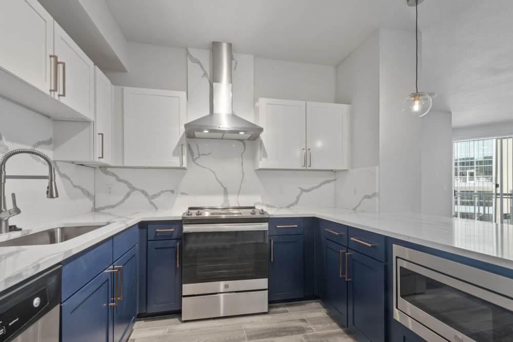 Premium-looking apartment kitchen with white top shelves and a chimney at The Lofts At West 7th in Fort Worth,Texas