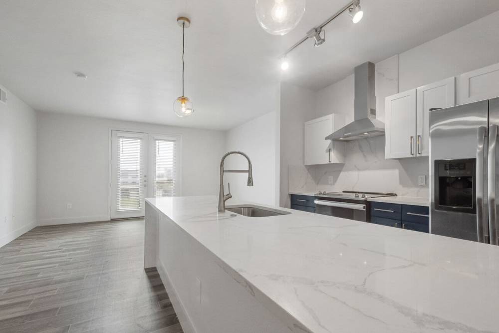 Kitchen with shiny white countertop and sink setup at The Lofts At West 7th in Fort Worth,Texas