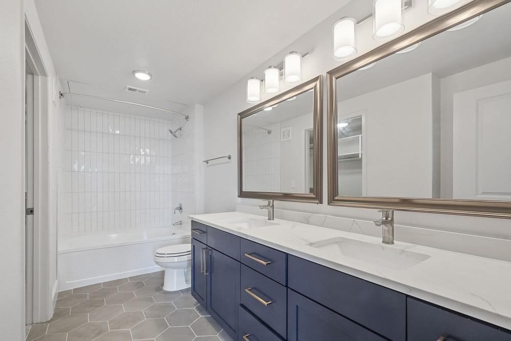 Bright bathroom with wooden cabinets at The Lofts At West 7th in Fort Worth,Texas